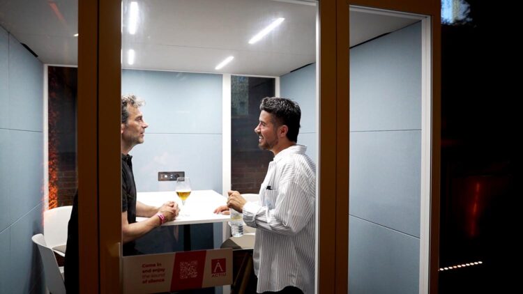 Dos asistentes dentro de la cabina Qyos de Actiu