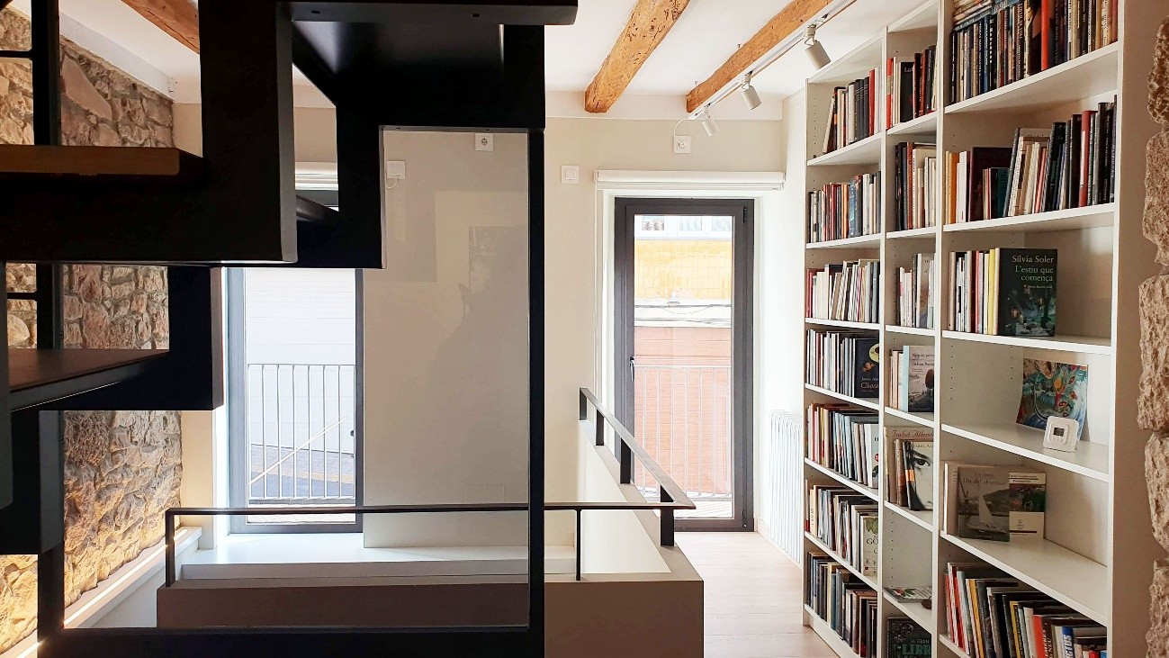 librería con escalera metálica y puerta al fondo