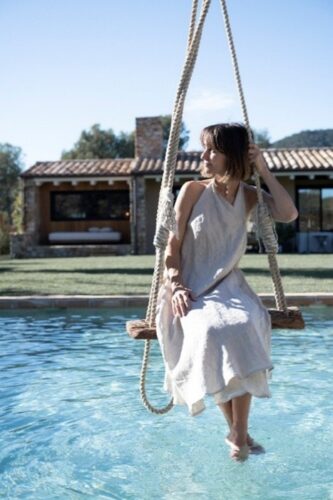 Clara D'Aussy interiorista en un columpio sobre piscina
