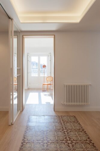 pasillo con fondo ventana y silla moderna
