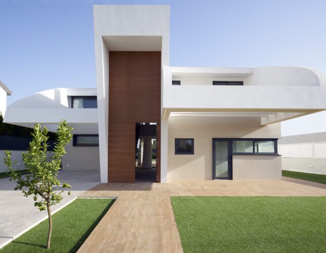 Arquitectura residencial moderna en la urbanización Torre en Conill con acceso central y doble altura.