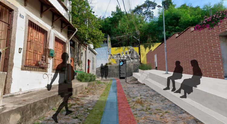 Calle estrecha empedrada con líneas verdes, azules y rojas pintadas en el suelo, bancos de concreto y un tótem informativo frente a un mural, representando la señalización del proyecto Sankofa en la Pequena África.