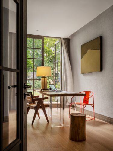 Wang Yizhou's Mountain (2023) converses playfully with an orange chair by Shangxia, while a table lamp by Alexander Lamont completes the vignette.