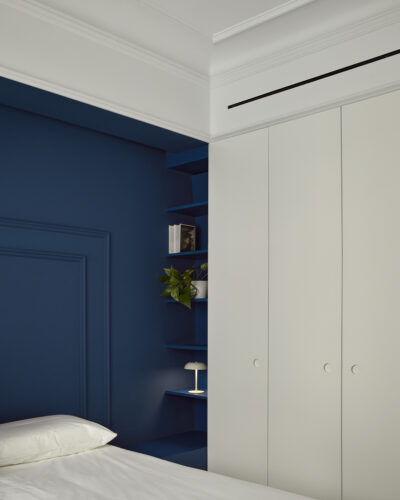 Dormitorio con molduras y pared azul en vivienda La Petxina por Studio Lucus