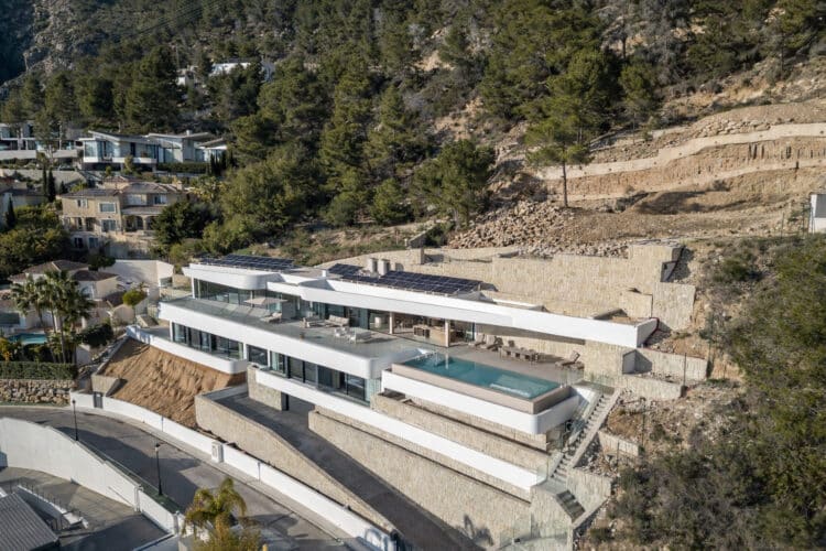 Vista aérea de la vivienda AH-802 integrada en la ladera de Altea Hills, proyecto de RGB Arquitectos.