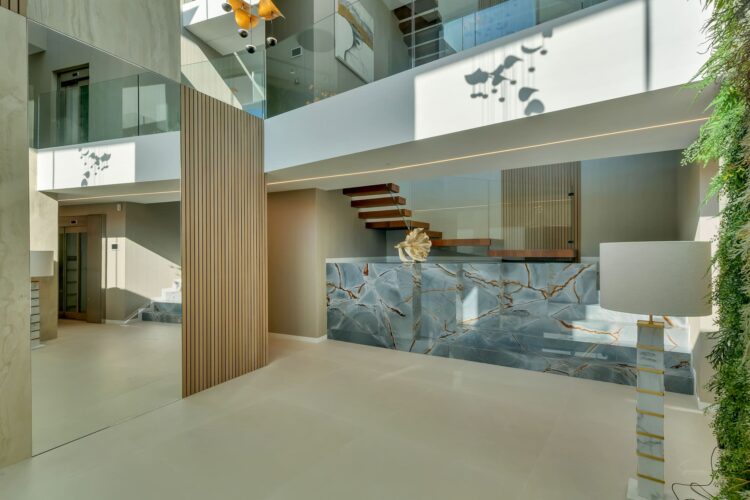 Escalera escultórica revestida con porcelánico Blue Roma en la vivienda AH-802.