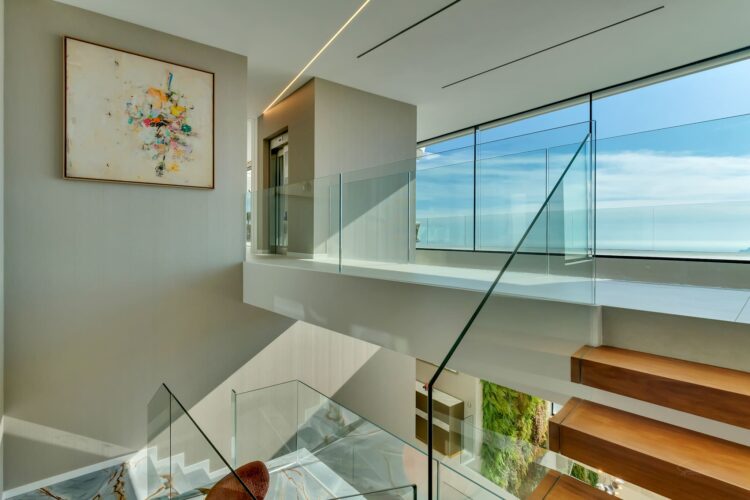 Vista superior de la escalera escultórica y la doble altura en la vivienda AH-802.