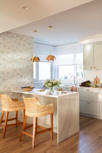 cocina abierta con península y taburetes en ratán